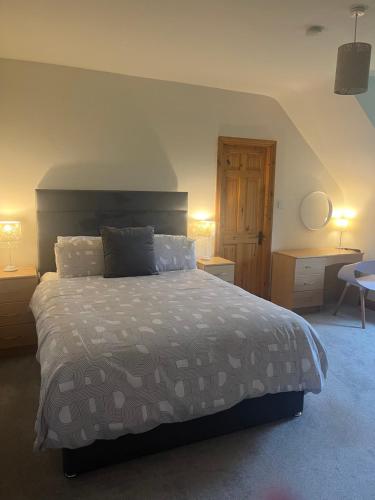 a bedroom with a bed and two lamps and a desk at Racecourse Lodge Apartment in Clifden