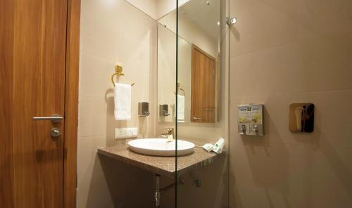 a bathroom with a sink and a glass shower at Hotel Le Roi,Haridwar@Har Ki Pauri in Haridwār
