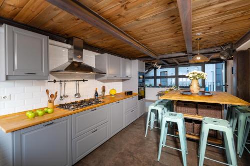 a kitchen with white cabinets and a wooden ceiling at Donna Fortuna in Catania