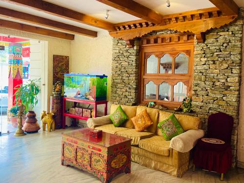 a living room with a couch and a stone wall at Three Jewels Boutique Hotel in Pokhara