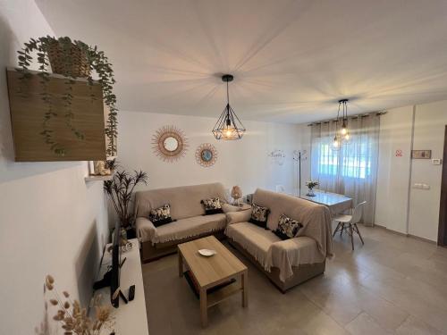 Casa Rural las Rosas de Benaojan في بيناوخان: غرفة معيشة مع أريكة وطاولة