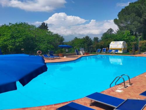 a large blue swimming pool with chairs and a rv at Holiday Travel Genius at Toscana Holiday Village Camping in San Romano