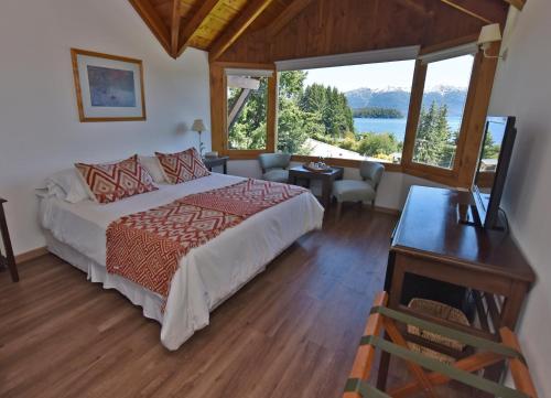 sypialnia z łóżkiem i widokiem na jezioro w obiekcie Hosteria Puertas Del Sol by Visionnaire w mieście Villa La Angostura