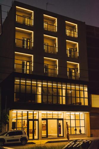 a building with a car parked in front of it at Britto Hotel in Aparecida