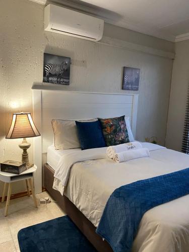 a bedroom with a bed and a night stand with a lamp at Lerato's in Vanderbijlpark