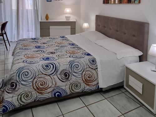 a bedroom with a bed with a comforter on it at Arco del Sole in Palermo