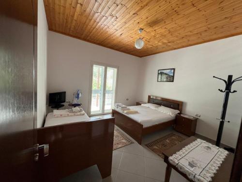 a bedroom with two beds and a wooden ceiling at Guest House Emiljos Flamur in Berat