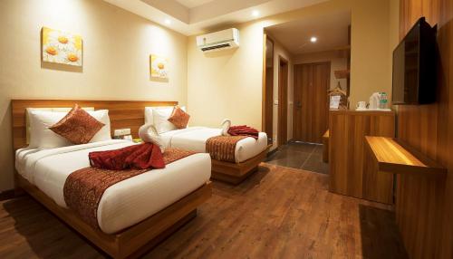 a hotel room with two beds and a television at Hotel Le Roi,Haridwar@Har Ki Pauri in Haridwār