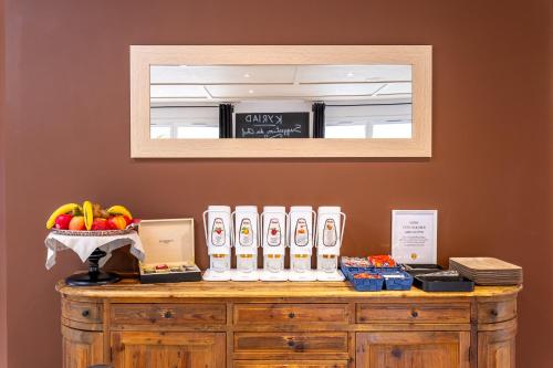 a counter with a shelf with fruit and a mirror at Kyriad Digne-Les-Bains in Digne-les-Bains