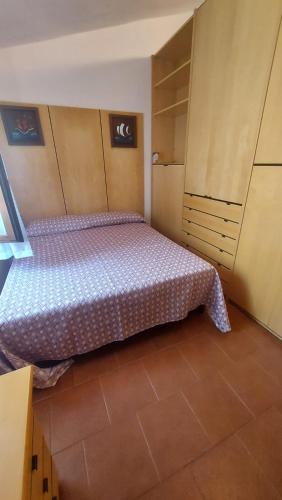 a small bedroom with a bed and a cabinet at Oasi CalaCapra - Palau Costa Smeralda in Proiettore