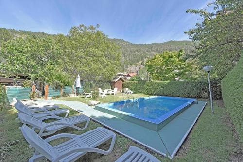 een achtertuin met een zwembad, stoelen en een hek bij Cabañas Humo Azul by Visionnaire in San Martín de los Andes