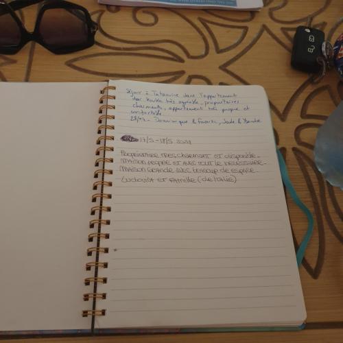 a notebook with writing on it sitting on a table at Dar kouka in Tataouine