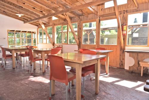 a dining room with tables and chairs and windows at Cabañas Humo Azul by Visionnaire in San Martín de los Andes