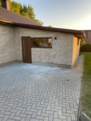 a brick building with a door and a patio at Atskiri apartamentai in Šilutė