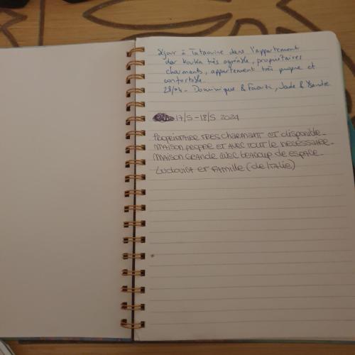 an open notebook with handwriting on the pages at Dar kouka in Tataouine