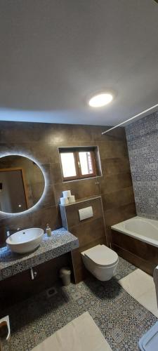 a bathroom with a toilet and a sink and a tub at House for rent in Žrnovo