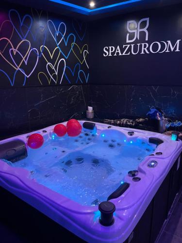 una vasca idromassaggio con luci davanti a un cartello di Spazuroom Luxury Suite a Mouscron