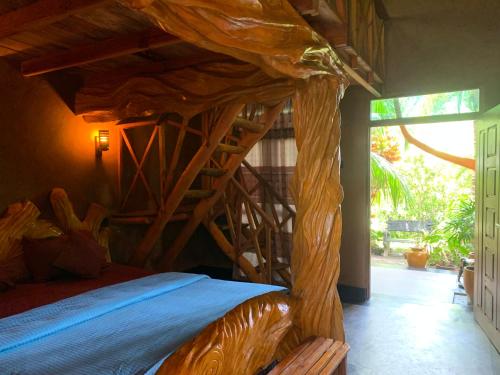 a bedroom with a wooden bed with a wooden spiral staircase at Ama Eco Lodge in Sigiriya