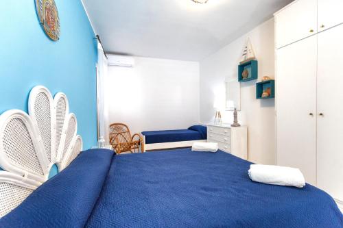 een blauwe slaapkamer met een bed en een stoel bij Casa Angela Lipari in Canneto