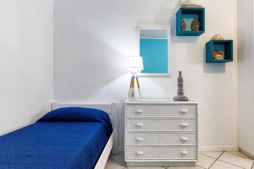 een slaapkamer met een blauw bed en een dressoir bij Casa Angela Lipari in Canneto
