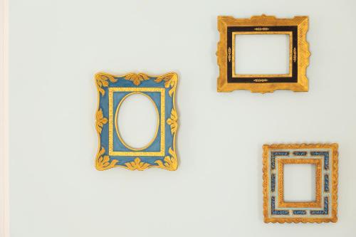 three framed mirrors hanging on a white wall at Marina di Petrolo Hotel & SPA in Castellammare del Golfo