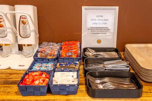 a table topped with boxes filled with different types of food at Kyriad Digne-Les-Bains in Digne-les-Bains