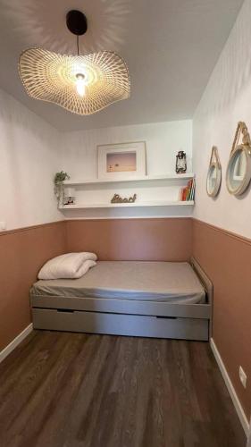 une petite chambre avec un lit dans une pièce dans l'établissement Bel appartement avec parking, face à la mer, à La Rochelle