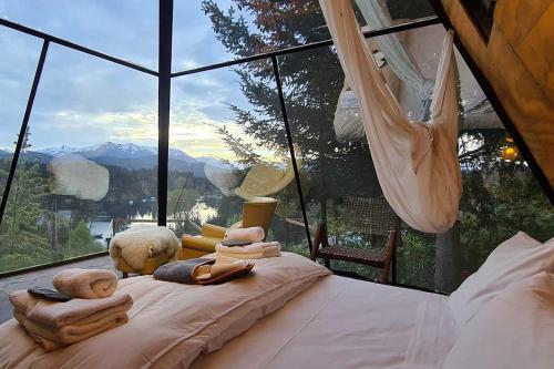 um quarto com uma cama em frente a uma janela em Puerto Manzano Suites by Visionnaire em Villa La Angostura