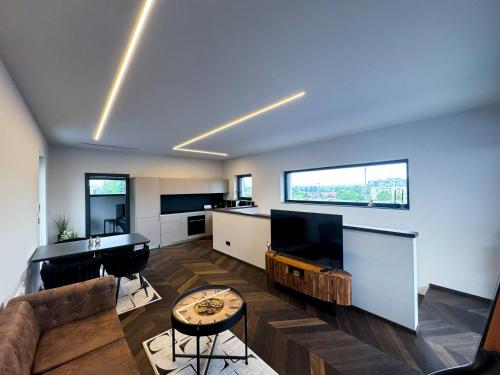 ein Wohnzimmer mit einem Sofa, einem Tisch und einem TV in der Unterkunft LUXUS-PENTHOUSE mit Weitblick über Graz in Graz