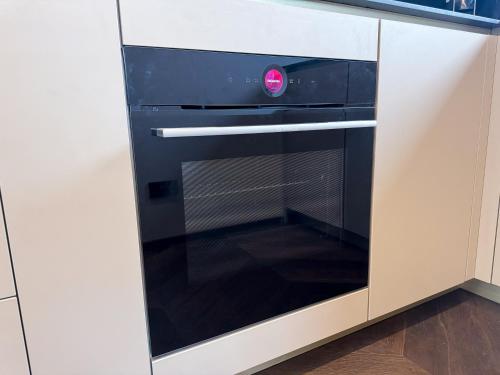 a black oven with a red dial in a kitchen at LUXUS-PENTHOUSE mit Weitblick über Graz in Graz