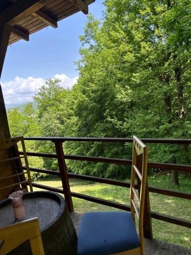 a balcony with a table and chairs and trees at Forest House Ninokristali in Visoko