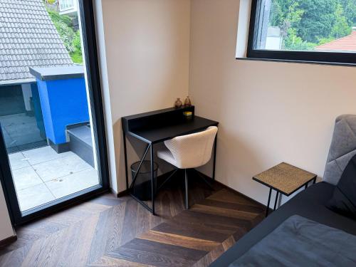 a small black desk in a room with a window at LUXUS-PENTHOUSE mit Weitblick über Graz in Graz