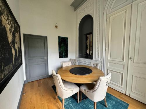 ein Esszimmer mit einem Holztisch und Stühlen in der Unterkunft Prestigieuse Suite Princeteau in Libourne