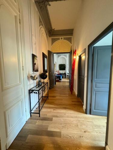 a hallway with a room with a table and a door at Prestigieuse Suite Princeteau in Libourne