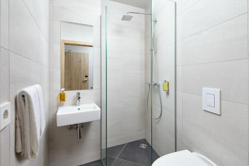 a bathroom with a shower and a sink and a toilet at Hotel Varmaland in Varmaland