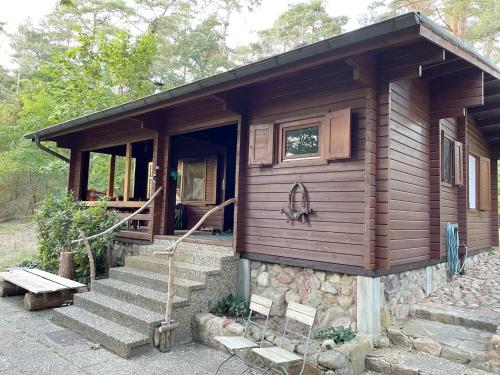 a wooden cabin with stairs leading to a door at Ferienhaus Waldeule in Karwitz