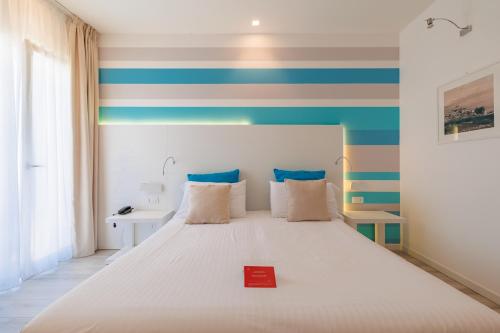 a bedroom with a bed with a red book on it at Marina di Petrolo Hotel & SPA in Castellammare del Golfo