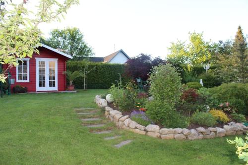 un jardin avec un chemin en pierre en face d'une maison rouge dans l'établissement Komfortable, gemütliche 4 Sterne Ferienwohnung, 