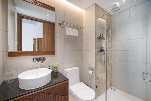 ein Bad mit einem Waschbecken, einem WC und einer Dusche in der Unterkunft Kings House Apec Condotel Phú Yên in Tuy Hoa