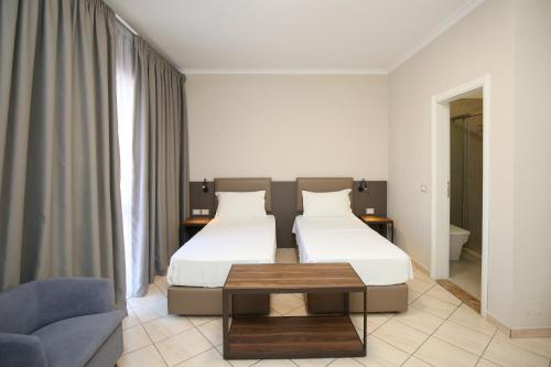 Habitación de hotel con 2 camas y sofá en Regina Garden Vlore en Vlorë