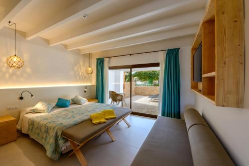 a bedroom with a bed and a couch at Hotel Son Trobat Wellness & Spa in Sant Llorenç des Cardassar