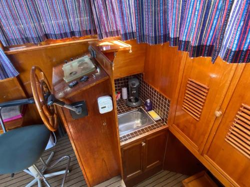 uma pequena cozinha com um lavatório num barco em Boat Stoer kamperen op het water - niet om mee te varen - lees hostprofiel-read host profile em Jutrijp