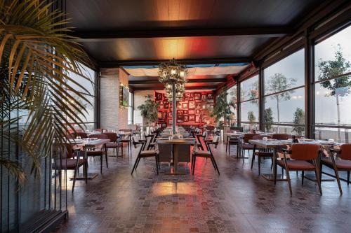 a restaurant with tables and chairs and windows at Concorde Tower Hotel & Casino in North Nicosia