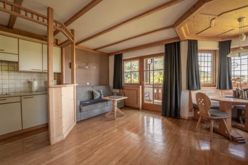 uma cozinha e sala de estar com uma mesa e um sofá em Residence Burghof em Siusi