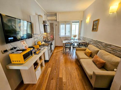 uma sala de estar com um sofá, uma televisão e uma cozinha em BariBello Apartment - 3 Bedrooms 3 Bathrooms - Bari Central Station em Bari