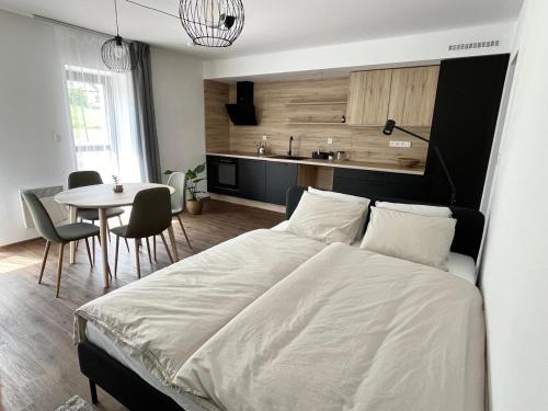 ein Schlafzimmer mit einem großen Bett und einem Tisch mit Stühlen in der Unterkunft Sáňky Apartmány in Liberec