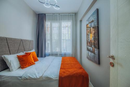 a bedroom with a bed with an orange blanket and a window at Taksim Wonder Suites in Istanbul