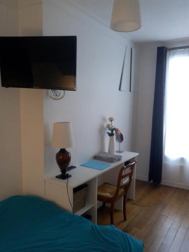 - une chambre avec un bureau, une lampe et un lit dans l'établissement Belle chambre avec sanitaires privatifs, à Paris