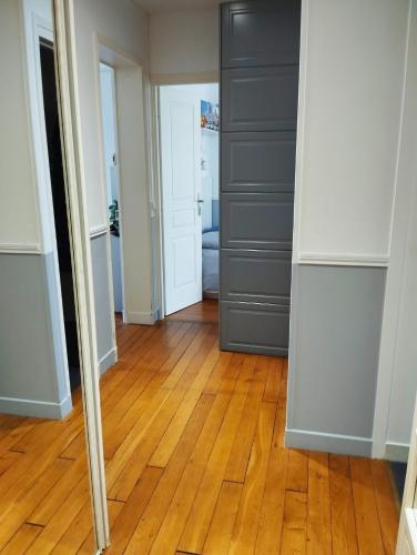 un couloir avec un miroir et un parquet en bois dur dans l'établissement Belle chambre avec sanitaires privatifs, à Paris