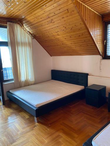 a bed in a room with a wooden ceiling at Luxury 3 BR Vila in a forest 10min drive from city center in Budapest